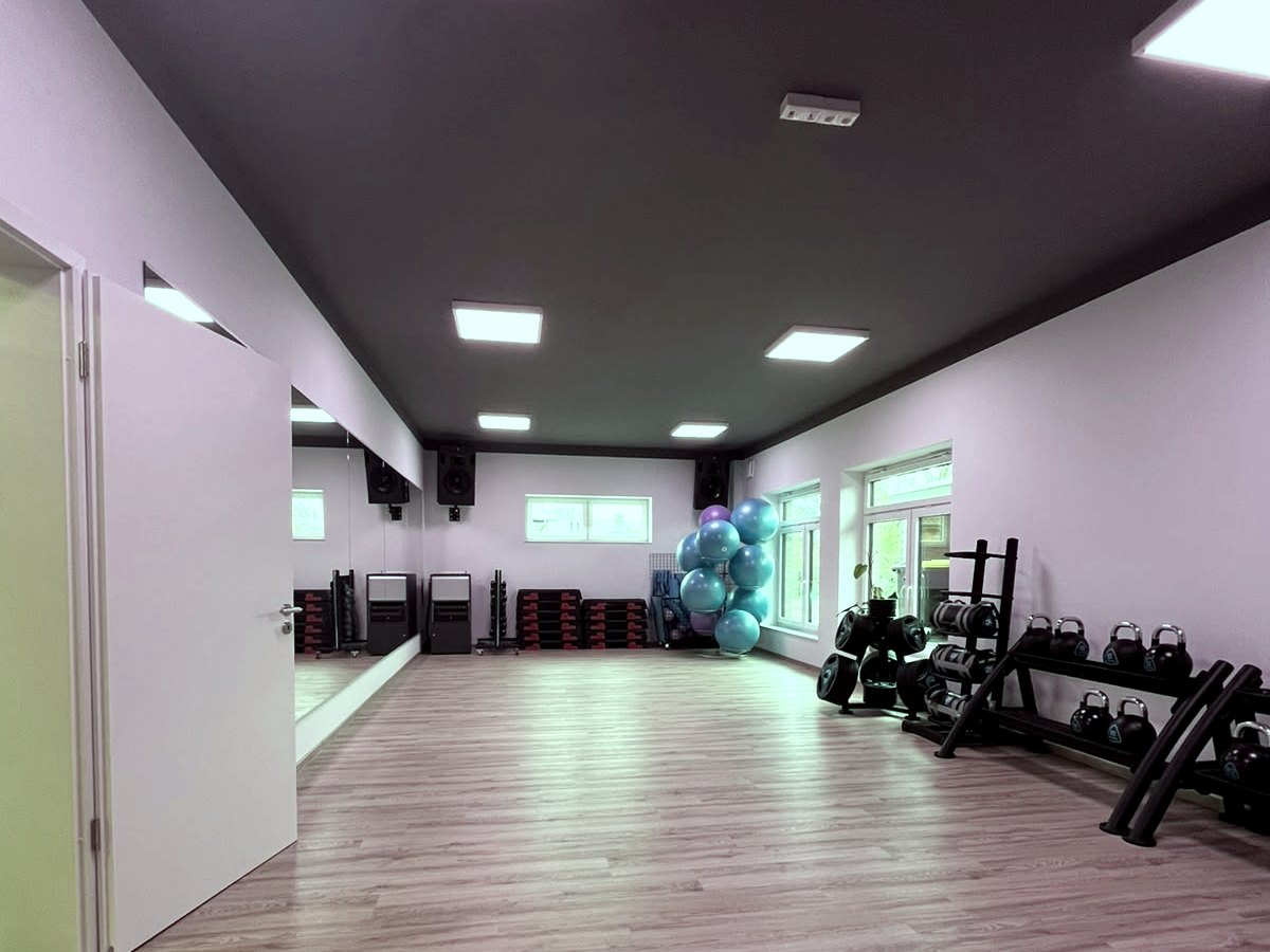 Heller Kursraum mit Spiegelwand, Kettlebells und Gymnastikbällen